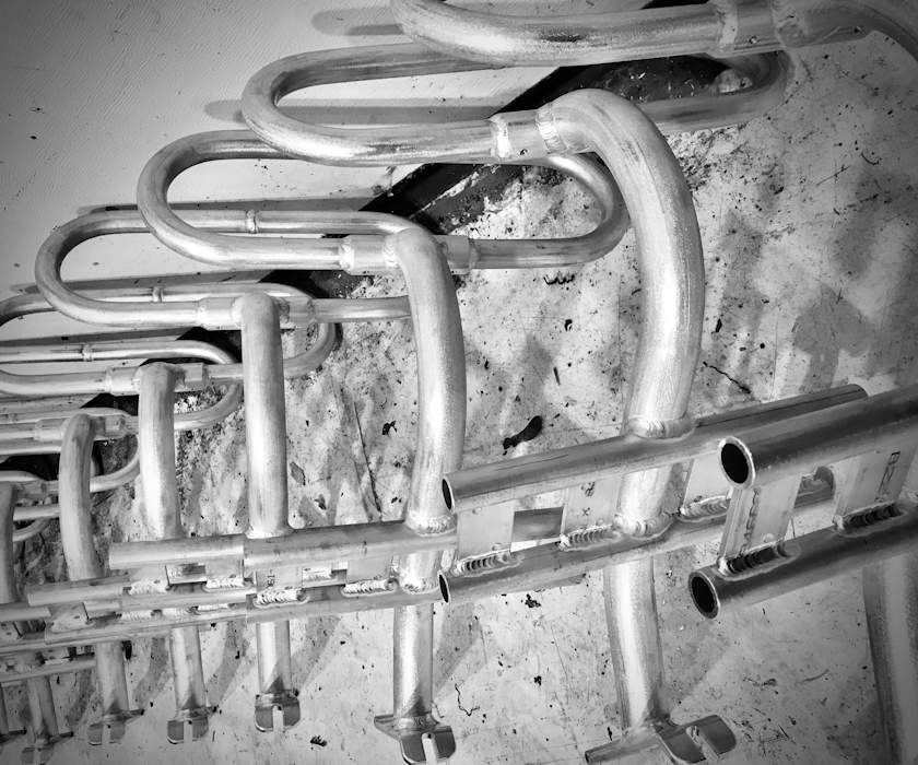 design for manufacturability- identical metal pieces of the fehn chair staged for assembly